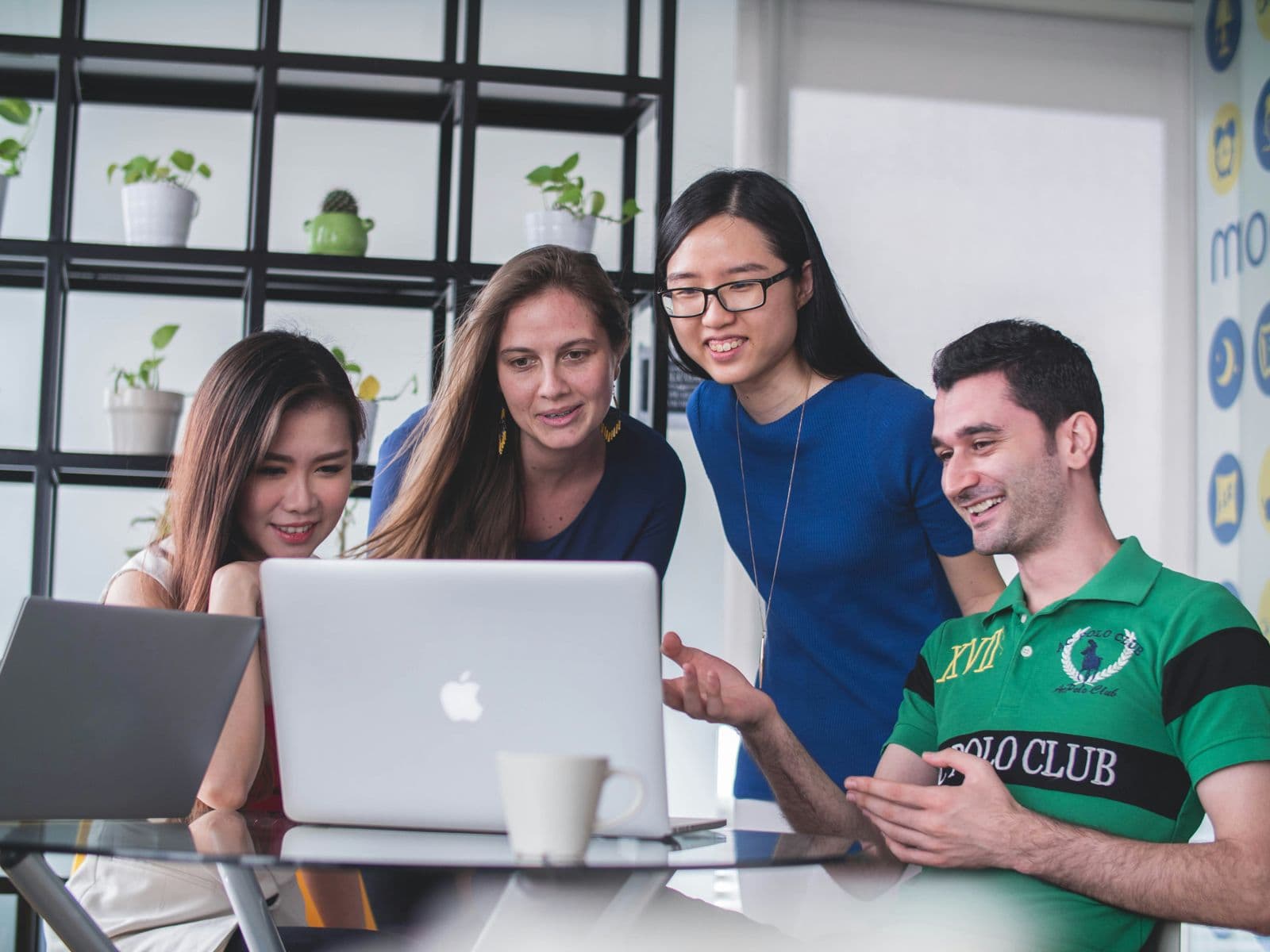 Équipe diverse en collaboration autour d'un MacBook
